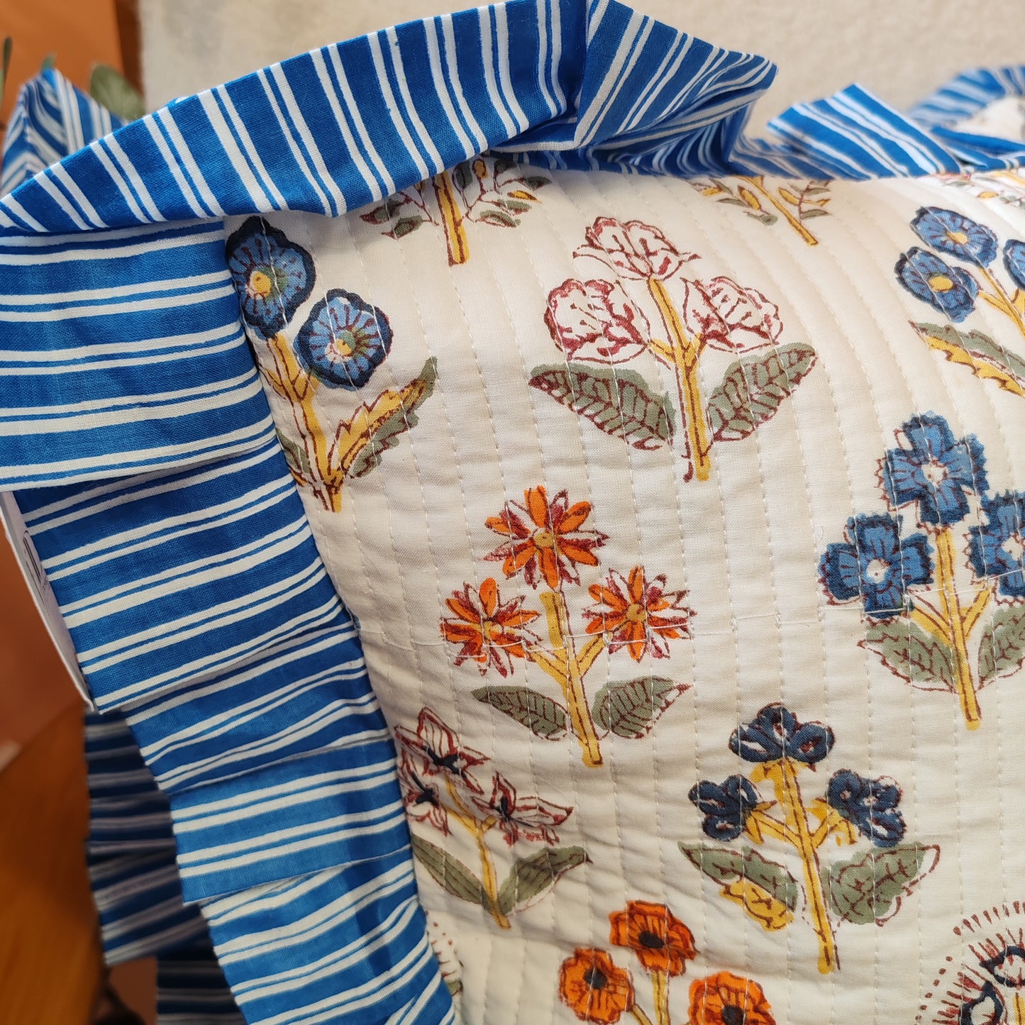 Large white / multi coloured floral cushion cover will a blue white striped frill